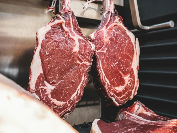 Raw cuts of meat on a stainless steel tray